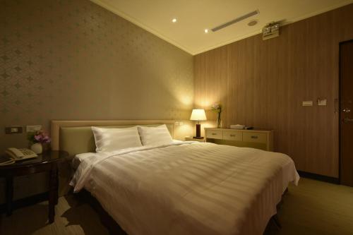 a bedroom with a large white bed and a telephone at A casa Hotel in Longtan