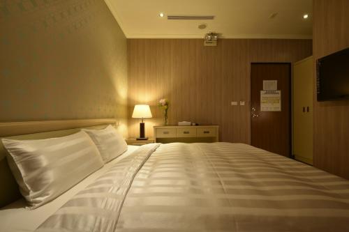 a bedroom with a large white bed in a room at A casa Hotel in Longtan
