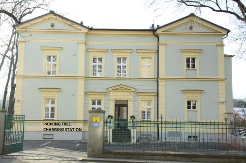 a large white house with a fence in front of it at Penzion U sv. Kryštofa in Prague