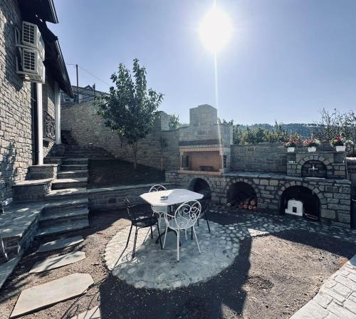 a table and chairs in a courtyard with a stone wall at Sunrise House - Swimming Pool in Berat
