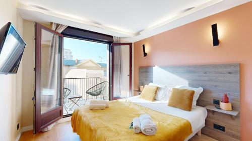 une chambre avec un grand lit et un balcon dans l'établissement Bluestay 53 - Appartement Chic au Cœur de Paris, à Paris