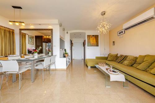 a living room and kitchen with a couch and a table at Herzliya Pituach Apartment with Pool, by the Beach in Herzelia 