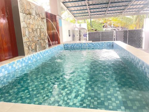 a swimming pool with blue tiles in a house at Sulong Inn - Private Pool Homestay in Kuantan, Pantai Sepat in Kuantan