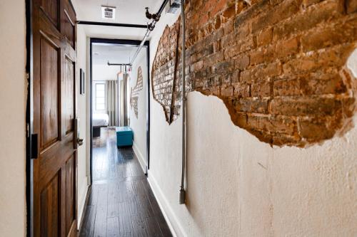 an empty hallway with a brick wall and a door at Firehouse Hostel in Austin