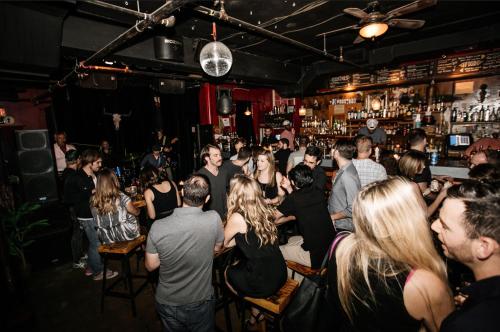 a group of people standing in a bar at Firehouse Hostel in Austin