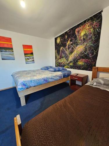 a bedroom with two beds and a painting on the wall at El valle in Copiapó