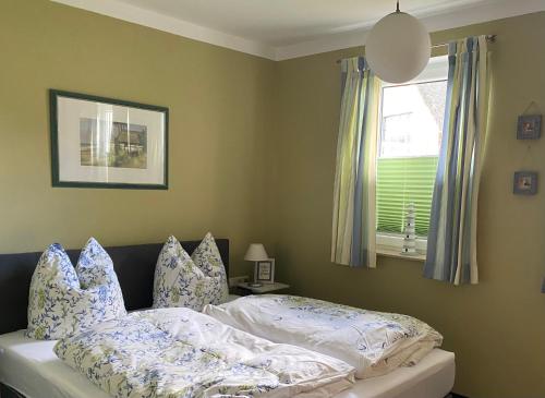 a bedroom with a bed with pillows and a window at Ferienhaus Ostseeblick in Wohlenberg