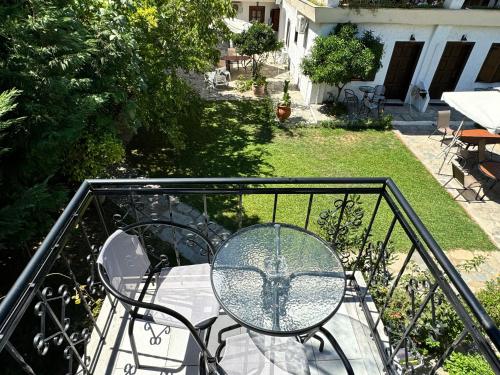 a glass table and chairs on a balcony at Villa Molos in Limenas