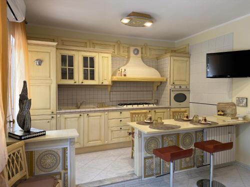 a kitchen with white cabinets and a island with stools at B&b Villa Romano in Salerno