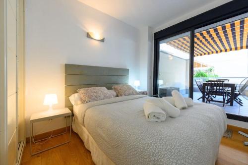 ein Schlafzimmer mit einem großen Bett und einem großen Fenster in der Unterkunft Moderno Apartamento TEMPORAL Familiar con Terraza SOD1 in Madrid