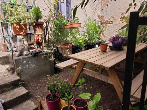 - une table de pique-nique en bois dans un jardin avec des plantes en pot dans l'établissement dortoir maricourt, au Bourget