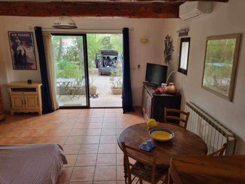 - un salon avec une table et une chambre avec une voiture dans l'établissement Studio en Provence, à Mimet