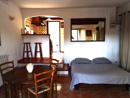 une chambre avec un lit, une table et un miroir dans l'établissement Studio en Provence, à Mimet