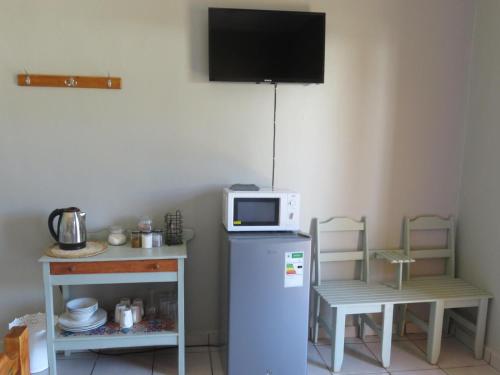 a small kitchen with a microwave on top of a refrigerator at Cobblestone Court in Colesberg