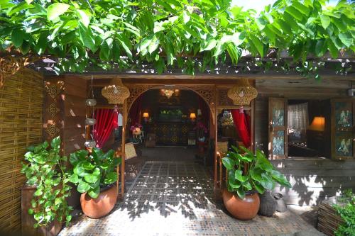 an entrance to a building with potted plants at Thai Thai Sukhothai Resort in Sukhothai
