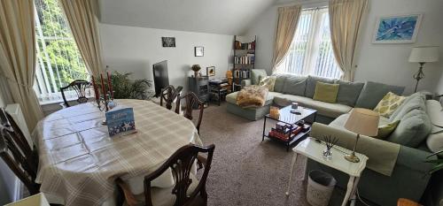 a living room with a table and a couch at Scotts Lodge Newcastle County Down in Newcastle