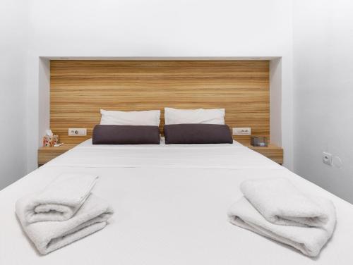 a bedroom with a white bed with two towels on it at Notus Chania Crete in Chania Town