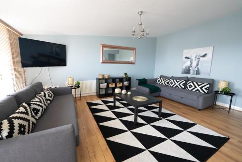 a living room with a couch and a table at City Hall Penthouse Duplex - Incredible Views & Sleeps 8 & Balcony & Very Modern and spacious in Belfast