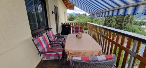 a porch with a table and chairs on a balcony at Ferienwohnung am Mondsee in Mondsee
