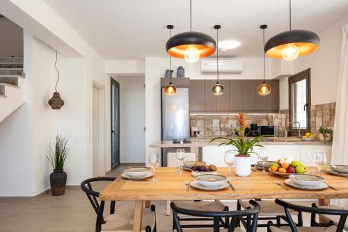 a kitchen and dining room with a wooden table and chairs at Villa Sun, Roussospiti in Roussospítion