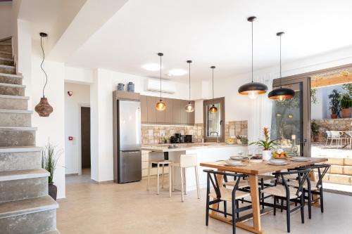 a kitchen and dining room with a table and chairs at Villa Sun, Roussospiti in Roussospítion