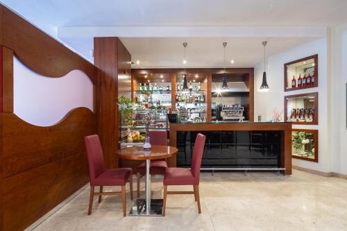 a restaurant with a table and chairs and a bar at Exe Toscana in Lucca