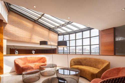 a lobby with two chairs and a table at Exe Toscana in Lucca