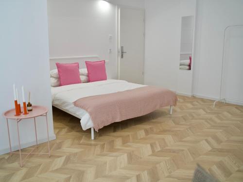 a bedroom with a bed with pink pillows and a table at Tzatziki Studios in Kavala