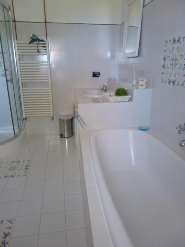 a white bathroom with a tub and a sink at Torre Galli-Dimora di Campagna in Gasponi