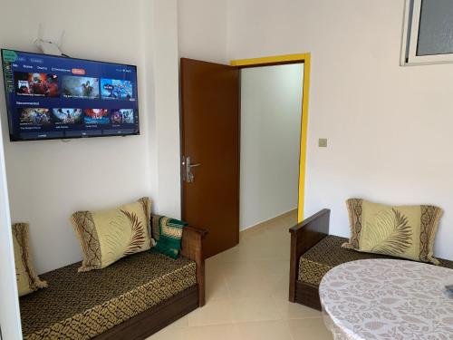 a bedroom with two chairs and a tv on the wall at العقارية in Beni Enzar