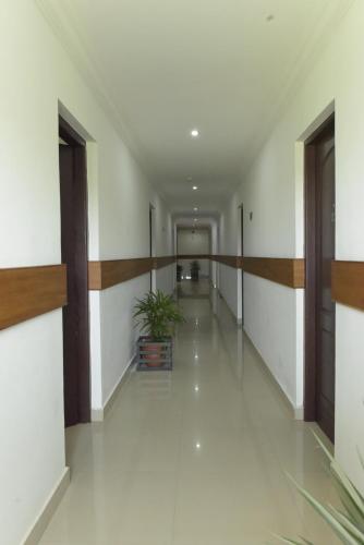 a hallway of a building with a plant in the middle at Paray Village County in Kollengode