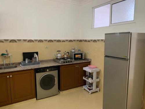 a kitchen with a refrigerator and a dishwasher at العقارية in Beni Enzar