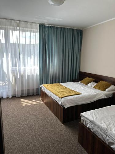 a bedroom with two beds and a window at NOCLEGI Kolonia Wokulskiego 4 in Świdnica