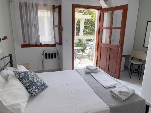 a bedroom with two beds and a door to a patio at Villa Molos in Limenas