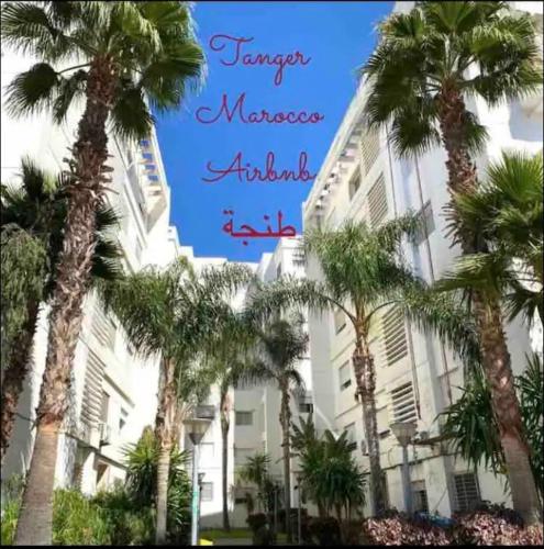 a group of palm trees in front of a building at Moderne appartement met tuin in Tangier