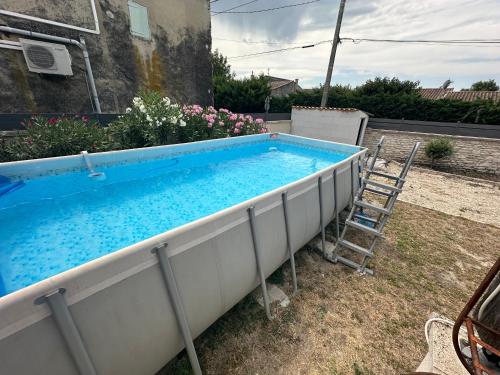 une grande piscine dans une cour avec une échelle dans l'établissement Maison Isle sur la sorgue, à LʼIsle-sur-la-Sorgue