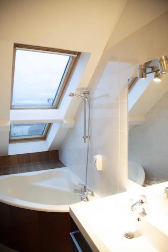 a bathroom with a tub and a sink and a window at Smartappart Cherbourg (la rose des vents) in Cherbourg en Cotentin