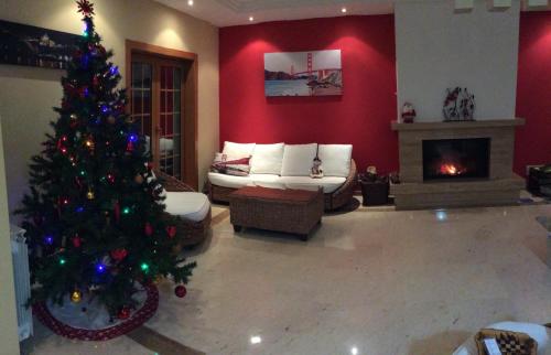 a living room with a christmas tree and a fireplace at Villa dos Teixos in Cascais