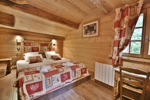 une chambre avec un lit dans une cabane en rondins dans l'établissement Chalet Au Bon Vieux Temps, au Grand-Bornand