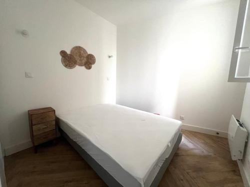 une chambre blanche avec un lit et un parquet dans l'établissement Soho - Le Corner Montpellier, à Montpellier