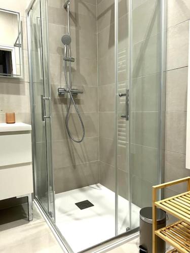 une douche avec une porte vitrée dans une salle de bain dans l'établissement Soho - Le Corner Montpellier, à Montpellier