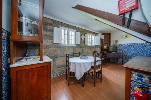 a kitchen and dining room with a table and chairs at Quinta Da Aldeia in Ponte de Lima