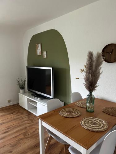een eetkamer met een tafel en een televisie bij The Climb in Koblenz