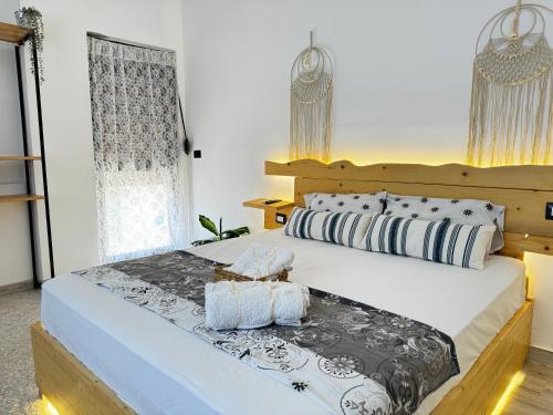ein Schlafzimmer mit einem großen Bett mit hölzernem Kopfteil in der Unterkunft Evoo Vlora in Vlorë