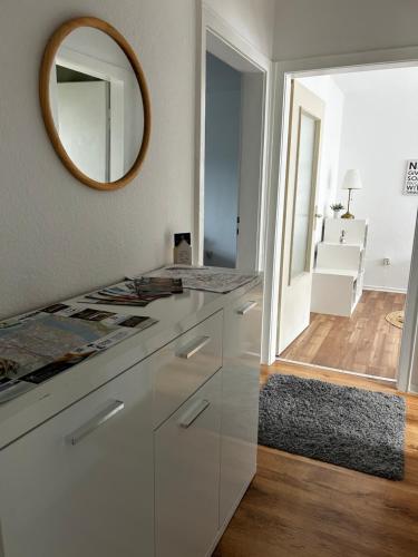 een badkamer met witte kasten en een spiegel bij The Climb in Koblenz