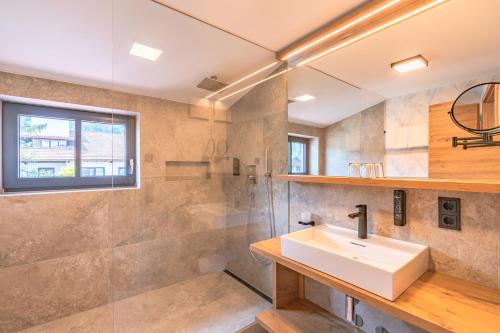 a bathroom with a sink and a shower at Hotel Alpensonne in Bad Wiessee