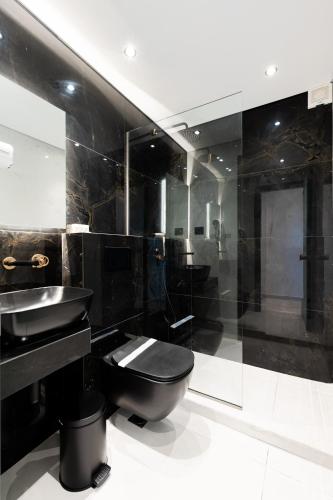 bagno nero con servizi igienici e lavandino di Kefi Executive Villa a Chrisi Ammoudia