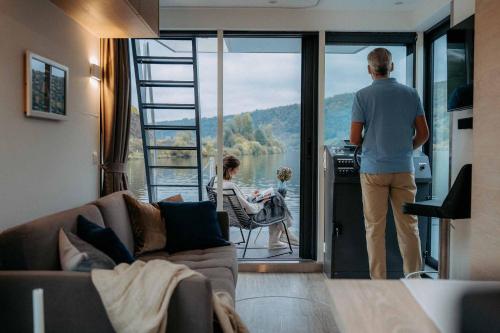 a man looking out the door of a house at Schwimmende Ferienwohnung auf der Saar in Merzig