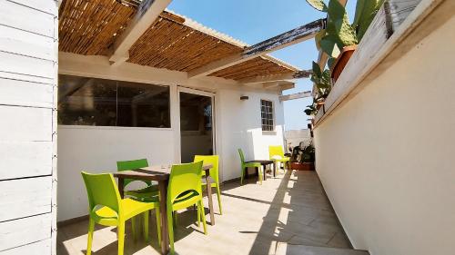 a patio with yellow chairs and a wooden table at Alle Volte Maison in Grumo Appula