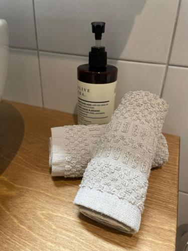 two towels on a table next to a bottle of soap at Odysseus Boutique Apartment in Ermioni